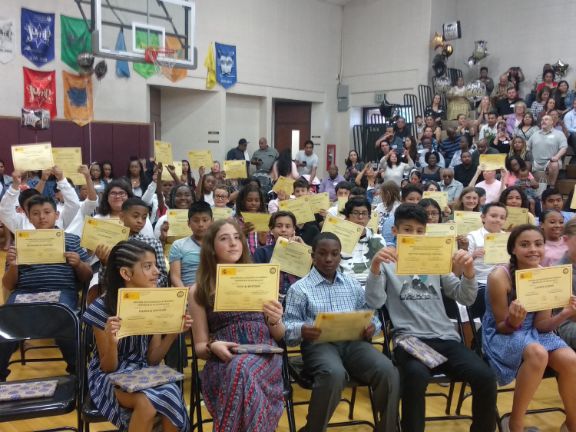 Vista de los alumnos de Forest Glen Elementary School con sus diplomas ISA