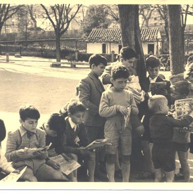 Fotografía antigüa de niños leyendo al aire libre