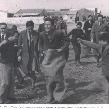 Fotografía antigüa de niños jugando a carrera de sacos