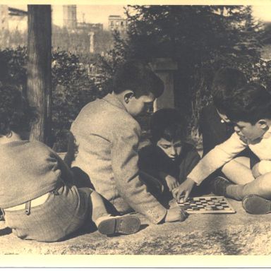 Fotografía antigüa de niños jugan a las damas en un tablero