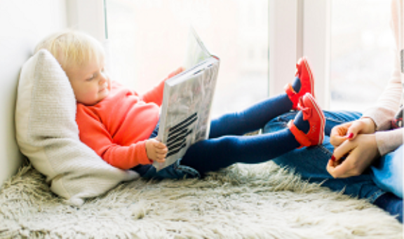 niña leyendo en una alfombra