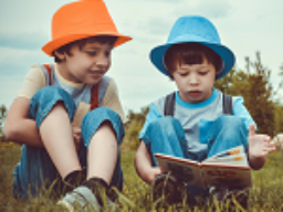 dos niños leyendo en el campo